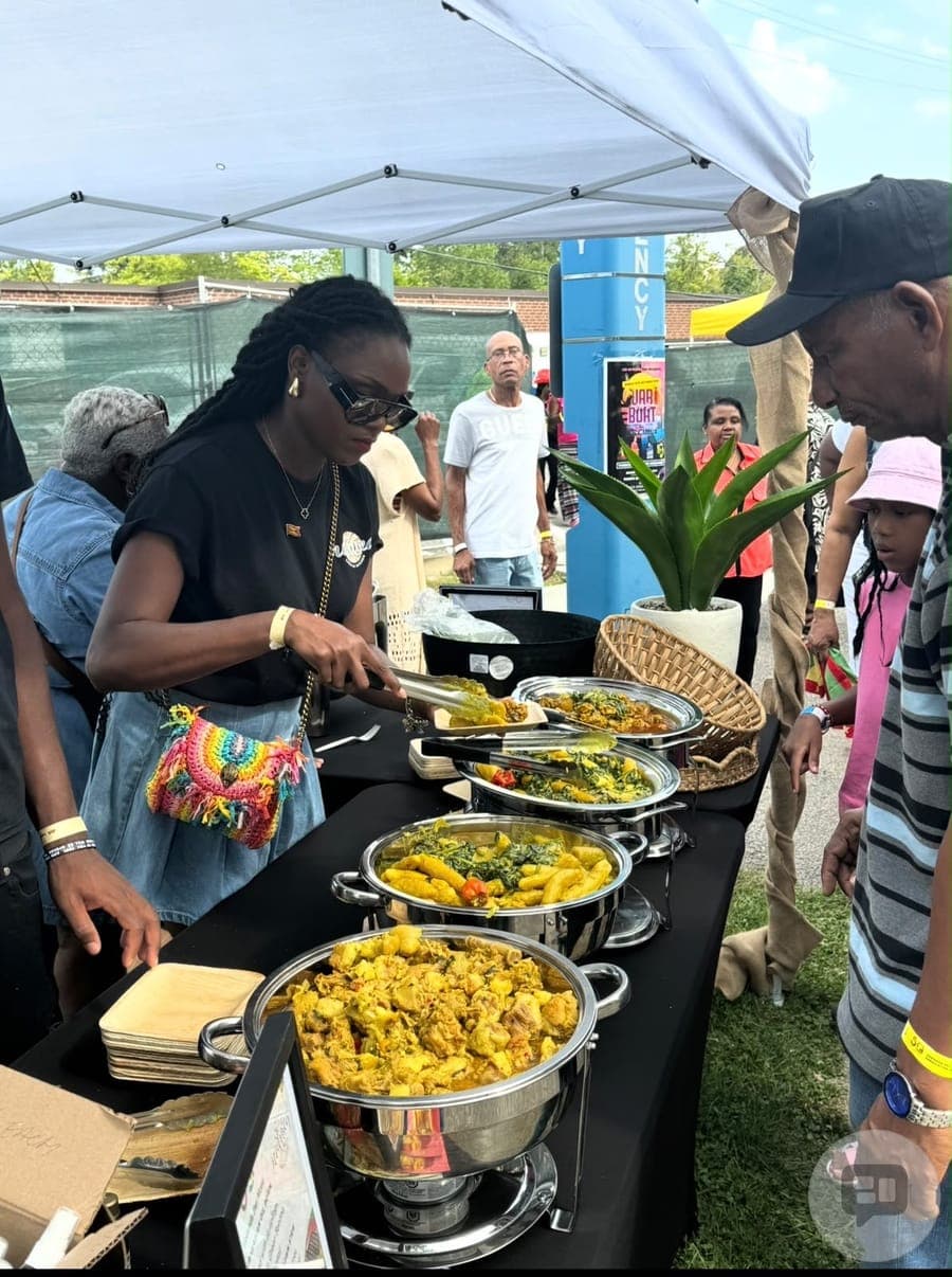 Guests serving themselves rice and stews from a buffet under an outdoor tent